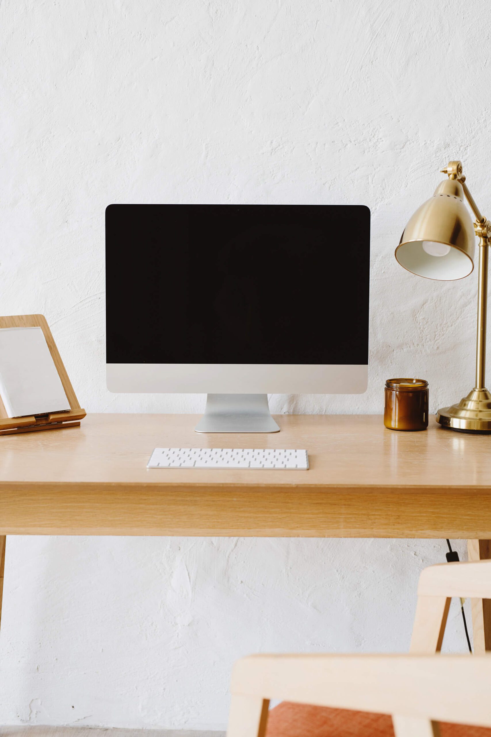 Desk with computer monitor, lamp, keyboard and other accessories