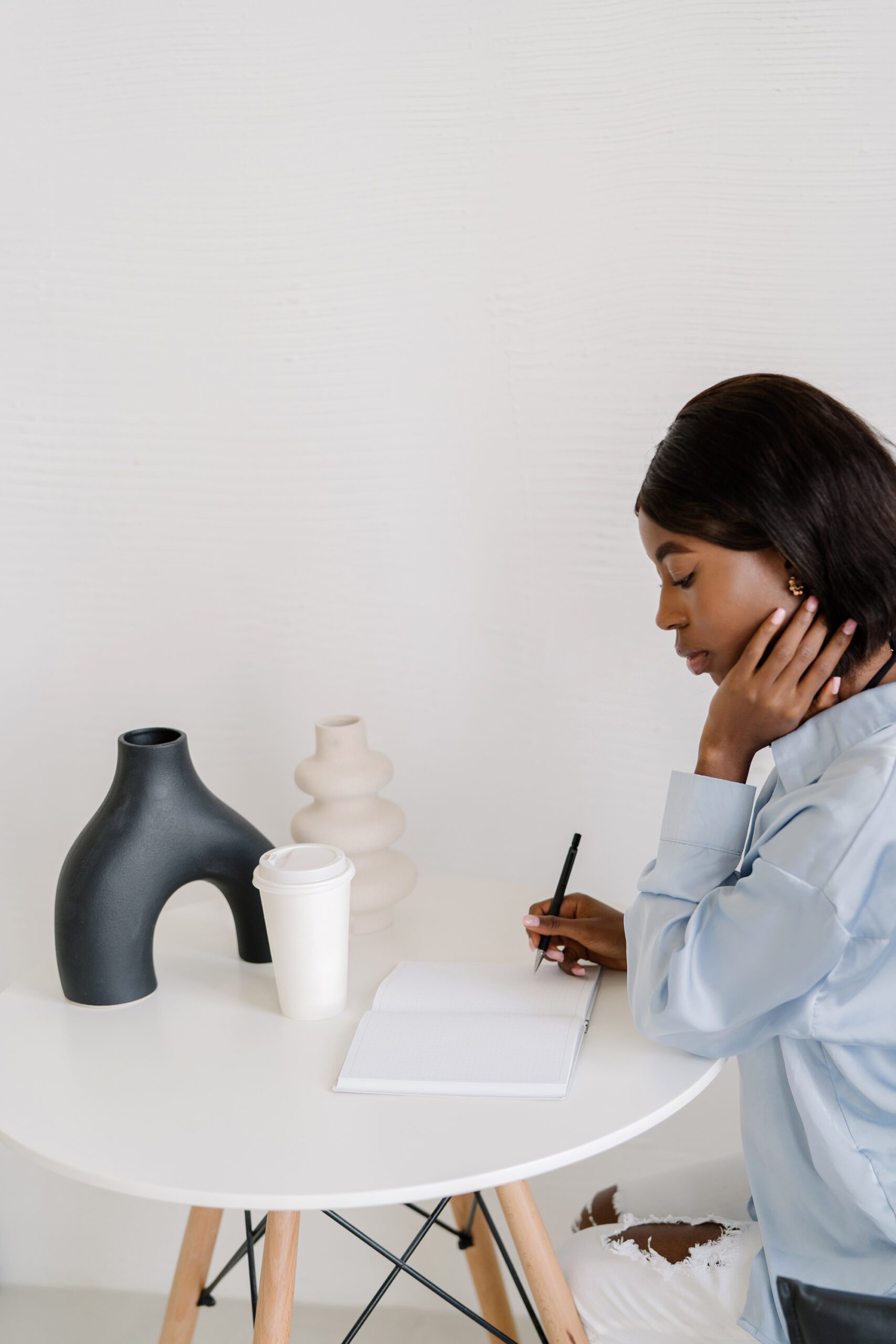 black woman writing in notebook at table