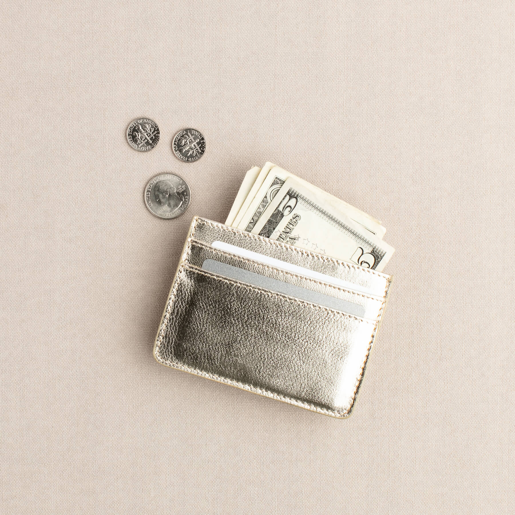 Silver wallet with cash and coins falling out